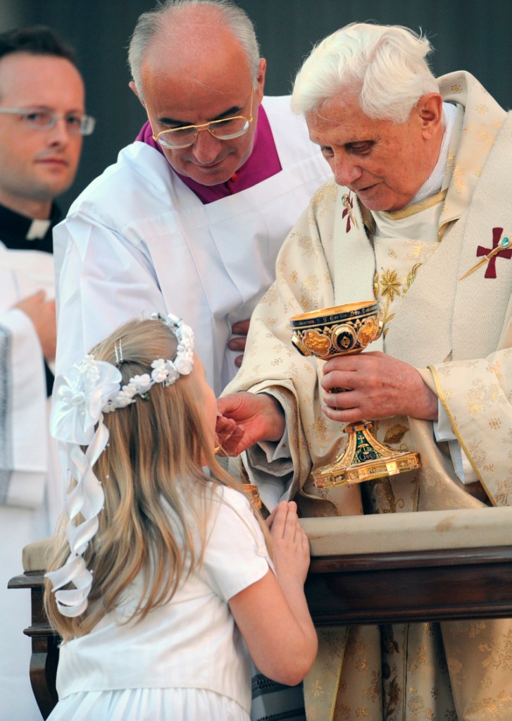GIRL KNEELS AS SHE RECEIVES COMMUNION FROM POPE