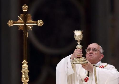 Pope Francis lifts up the chalice as he leads a vigil mass during Easter celebrations at St. Peter's Basilica in the Vatican